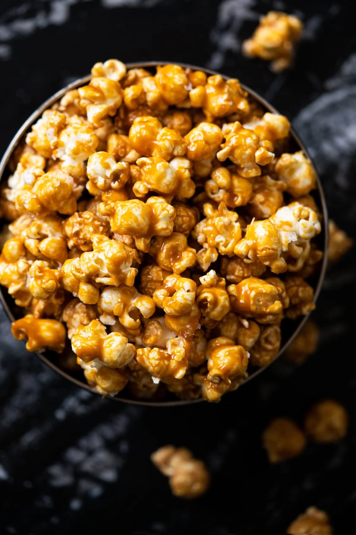 Close-up of caramel popcorn in a bowl, showcasing golden kernels with a glossy caramel coating.